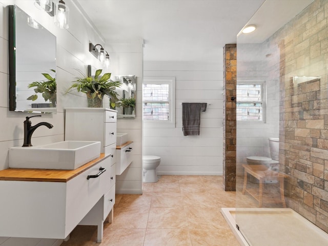 bathroom featuring vanity, tile patterned flooring, toilet, and a shower