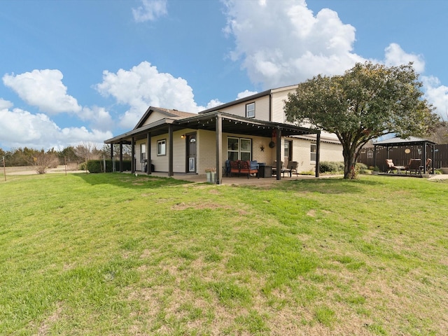 back of property with a gazebo, a patio, and a lawn