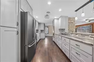 kitchen featuring white cabinetry, stainless steel fridge, and dark hardwood / wood-style flooring