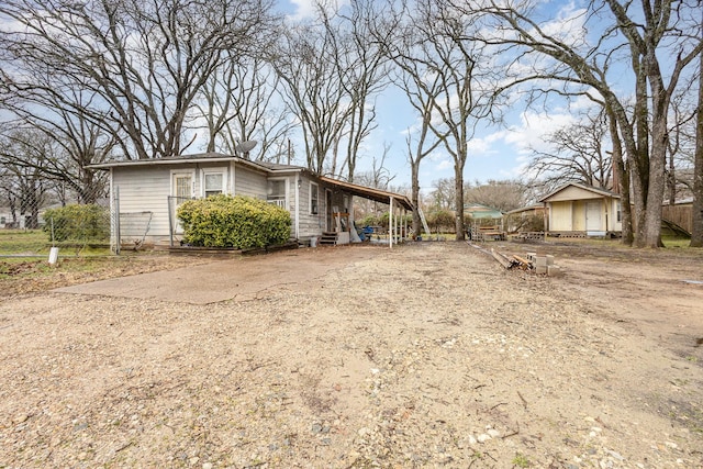 view of side of property featuring fence and dirt driveway