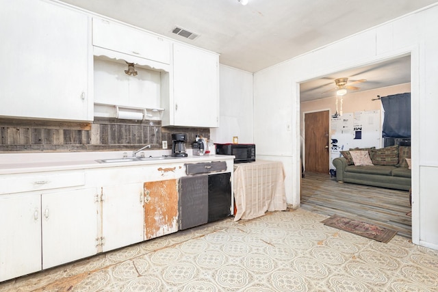 kitchen featuring visible vents, white cabinets, black microwave, and light countertops