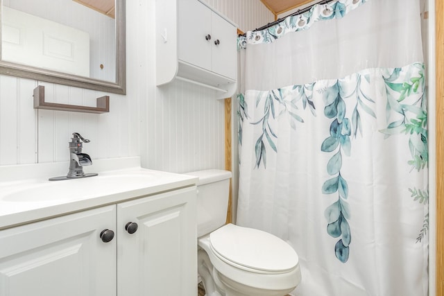 full bath featuring a shower with curtain, toilet, and vanity