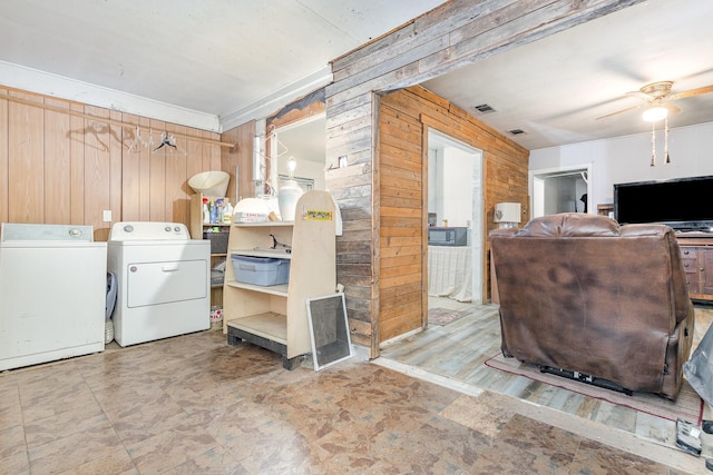 laundry area with visible vents, washing machine and dryer, laundry area, and wood walls