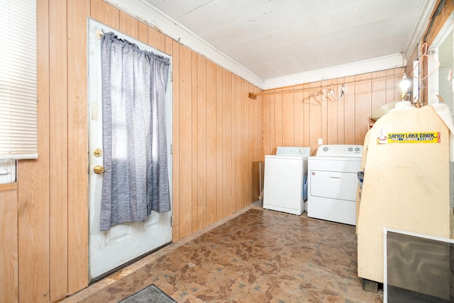 washroom featuring crown molding, laundry area, wood walls, and washing machine and clothes dryer