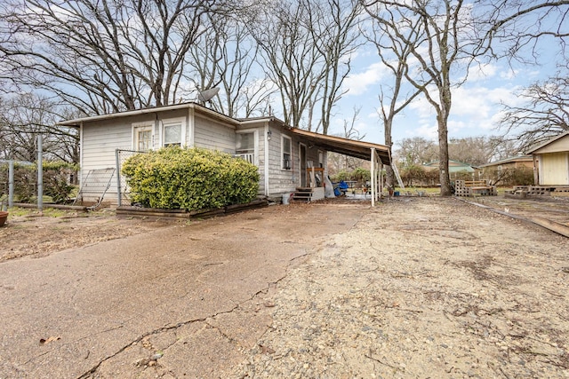 view of side of home with an attached carport, driveway, and entry steps