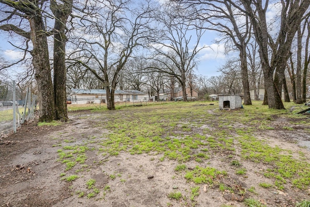 view of yard featuring an outbuilding, a shed, and fence