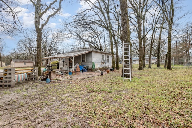 view of yard with a patio, an outbuilding, and fence