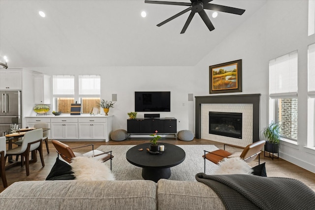 living room featuring ceiling fan, light wood finished floors, a glass covered fireplace, and recessed lighting