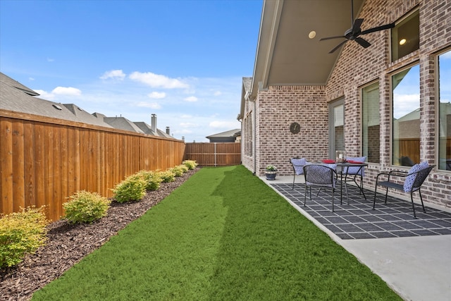 view of yard featuring a ceiling fan, a fenced backyard, and a patio