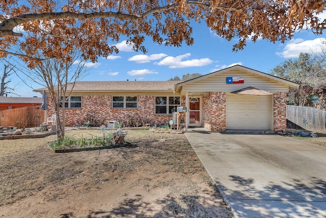 ranch-style home with a garage, concrete driveway, brick siding, and fence