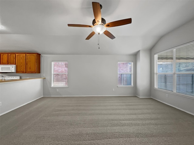 unfurnished living room featuring vaulted ceiling, light carpet, and ceiling fan