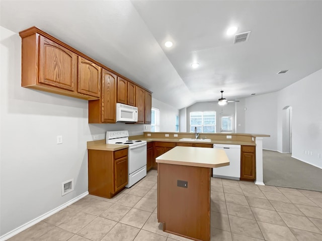 kitchen with lofted ceiling, sink, white appliances, a center island, and kitchen peninsula