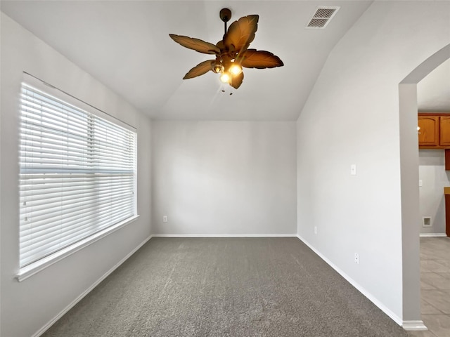 spare room with lofted ceiling, light carpet, and ceiling fan