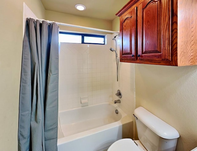 bathroom featuring shower / bathtub combination with curtain and toilet