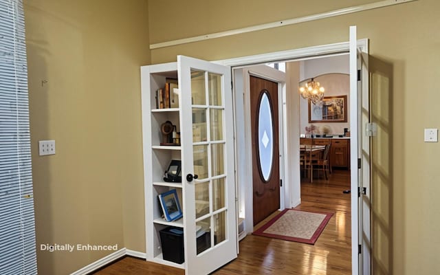 entrance foyer with a chandelier, dark hardwood / wood-style flooring, and french doors