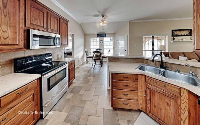 kitchen featuring sink, ornamental molding, tasteful backsplash, and stainless steel appliances