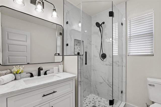 bathroom with a marble finish shower, toilet, and vanity