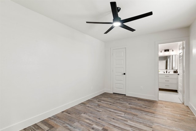 unfurnished bedroom with ceiling fan, ensuite bathroom, light wood-type flooring, and baseboards