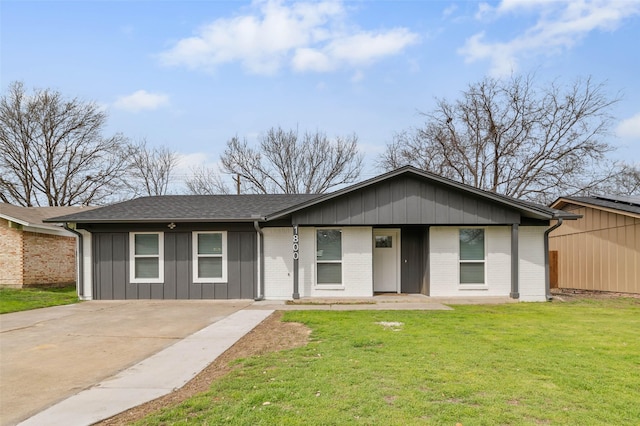 single story home with brick siding, board and batten siding, a shingled roof, and a front lawn