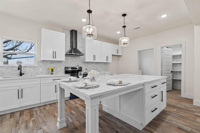 kitchen with tasteful backsplash, a sink, wall chimney range hood, electric stove, and dark wood-style flooring