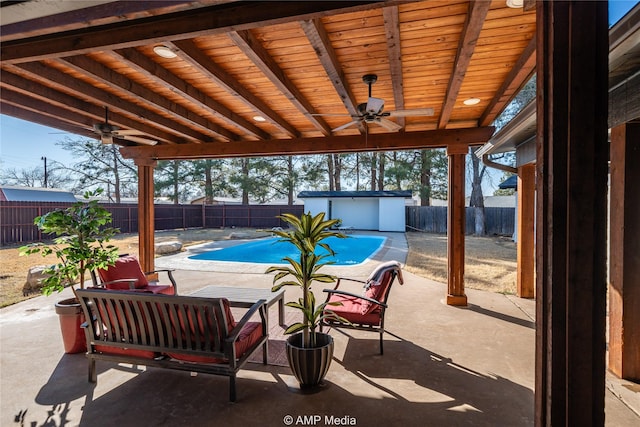 view of patio / terrace with a fenced in pool, a storage shed, outdoor lounge area, and ceiling fan