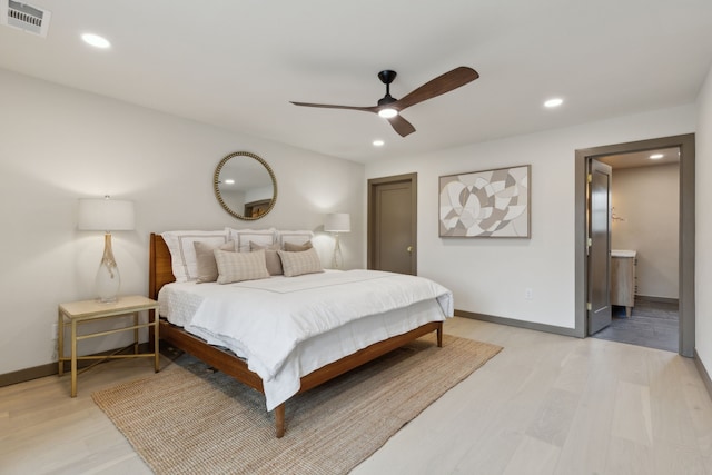 bedroom featuring ensuite bath, ceiling fan, and light wood-type flooring