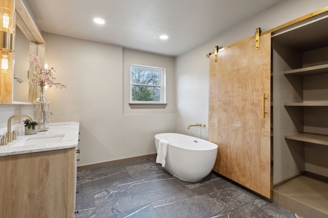 bathroom featuring a washtub and vanity