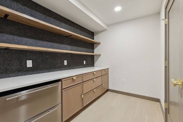 kitchen with tasteful backsplash, light hardwood / wood-style flooring, and stainless steel dishwasher