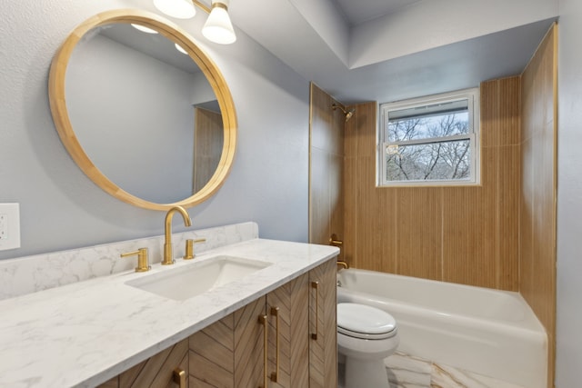 full bathroom featuring tiled shower / bath, vanity, and toilet