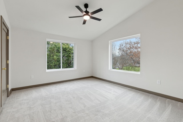 carpeted spare room with vaulted ceiling and ceiling fan