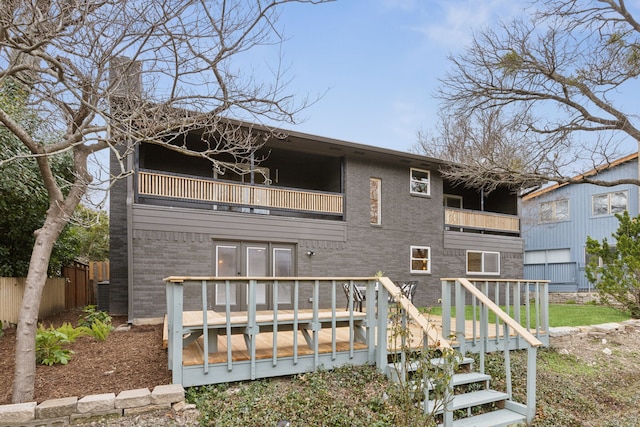 rear view of house with a wooden deck and a balcony