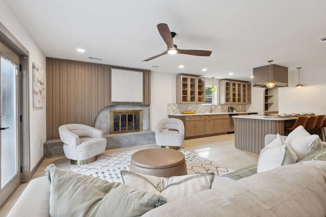 living room with ceiling fan, a premium fireplace, and light hardwood / wood-style flooring