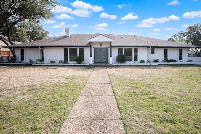 ranch-style home featuring a front lawn and french doors