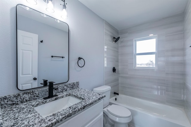 full bathroom featuring vanity, tiled shower / bath combo, and toilet