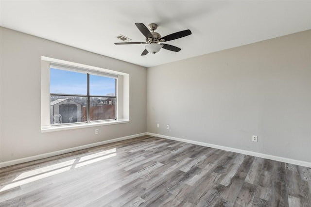 spare room with hardwood / wood-style flooring and ceiling fan