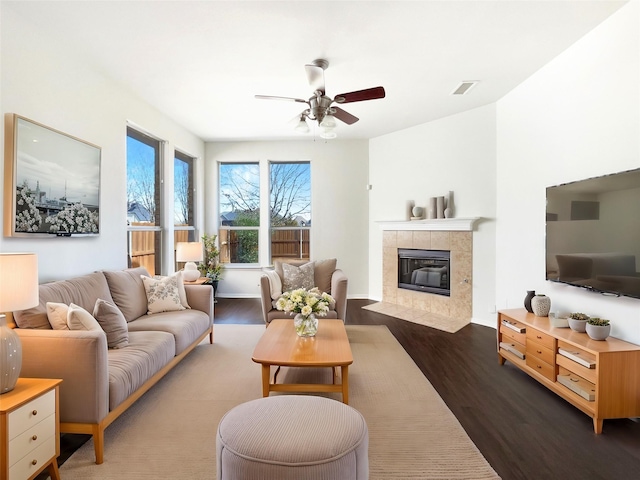 living room with ceiling fan, dark wood-type flooring, and a fireplace