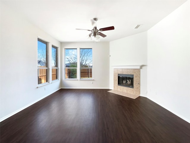 unfurnished living room with ceiling fan, dark hardwood / wood-style floors, and a fireplace