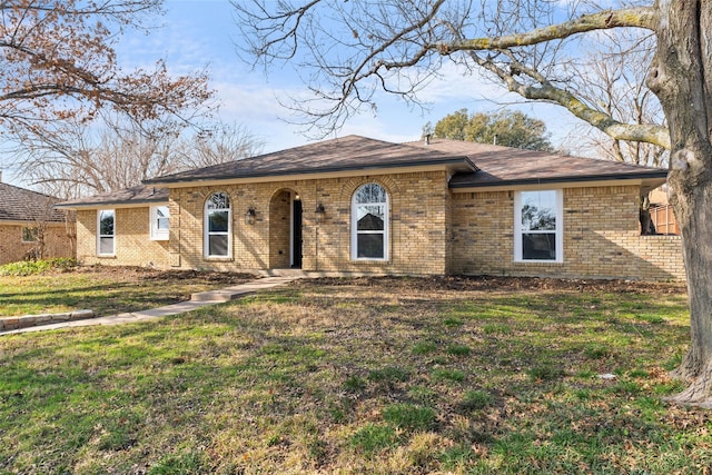 ranch-style home featuring brick siding and a front lawn