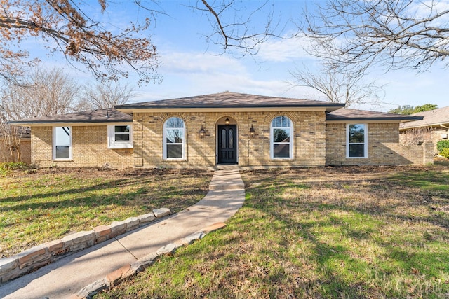 view of front of house with brick siding and a front lawn