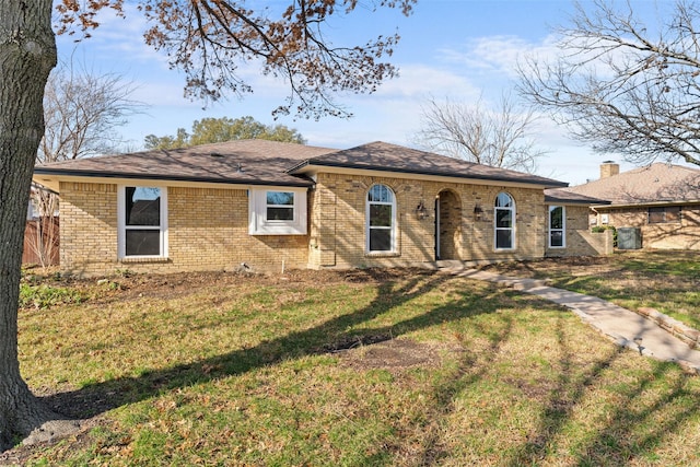 ranch-style house with brick siding, fence, and a front yard