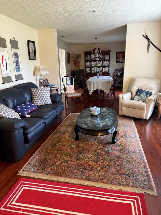 living room featuring dark wood-type flooring and a textured ceiling