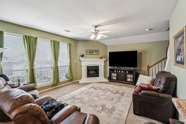 living room with light colored carpet, a textured ceiling, and ceiling fan