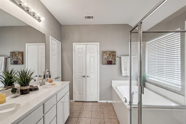 bathroom featuring independent shower and bath, vanity, and tile patterned flooring