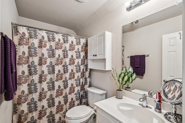 bathroom featuring vanity, a textured ceiling, and toilet