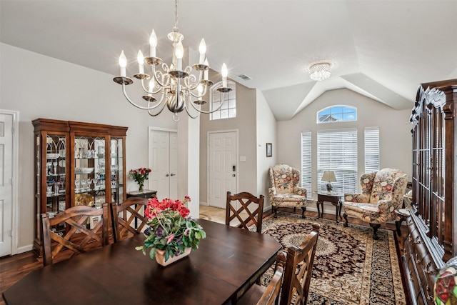 dining area featuring lofted ceiling and a notable chandelier