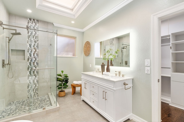 bathroom with a shower with door, crown molding, vanity, and a skylight