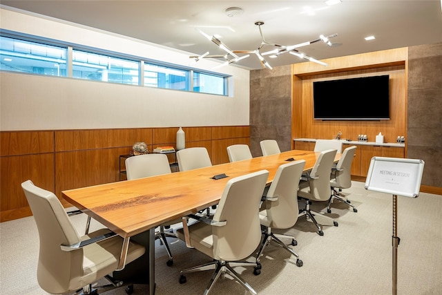 carpeted office featuring a chandelier and wood walls