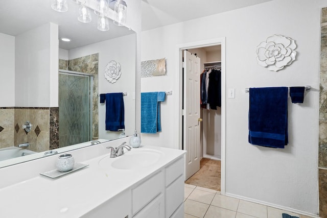 2312 Bantry Ln, Arlington, TX 76002 - full bathroom featuring tile patterned floors, a stall shower, a walk in closet, vanity, and a garden tub