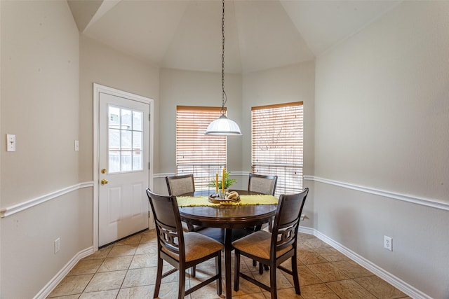 dining area featuring light tile patterned floors and vaulted ceiling