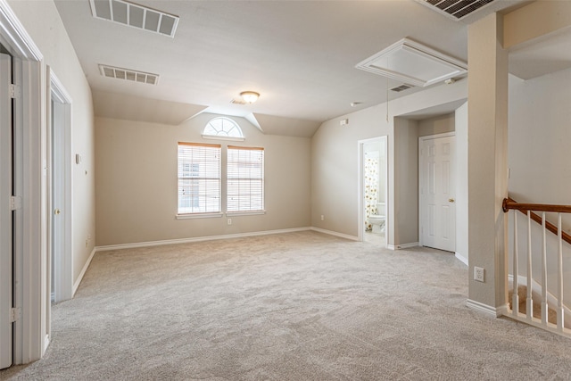 unfurnished room featuring light colored carpet and vaulted ceiling